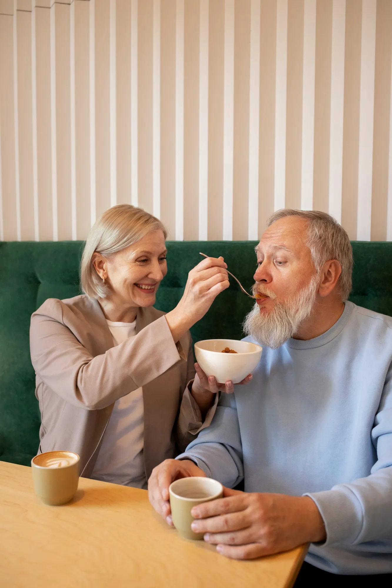 senior man standing at a dining table where the family is seated, enjoying a home-cooked meal